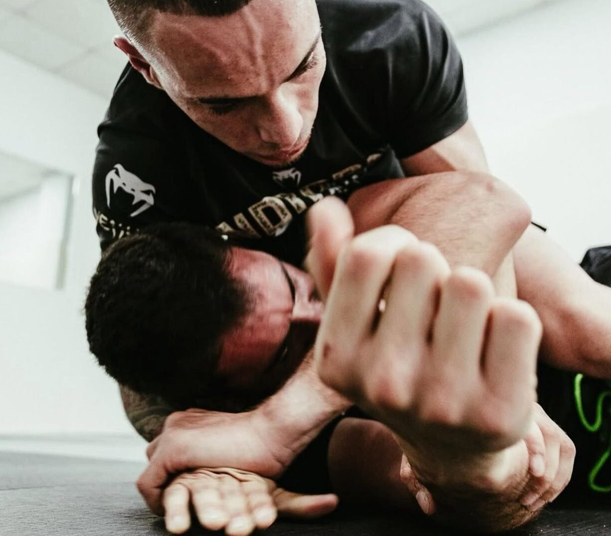Alumno practicando defensa en suelo en clase de BJJ en Barcelona.