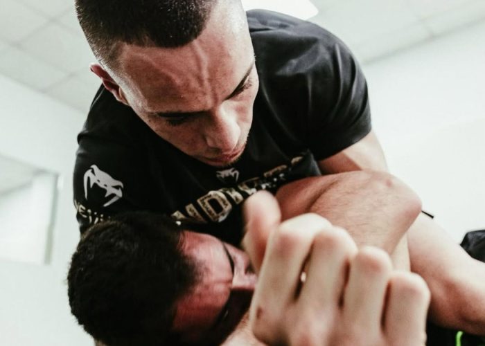 Alumno practicando defensa en suelo en clase de BJJ en Barcelona.